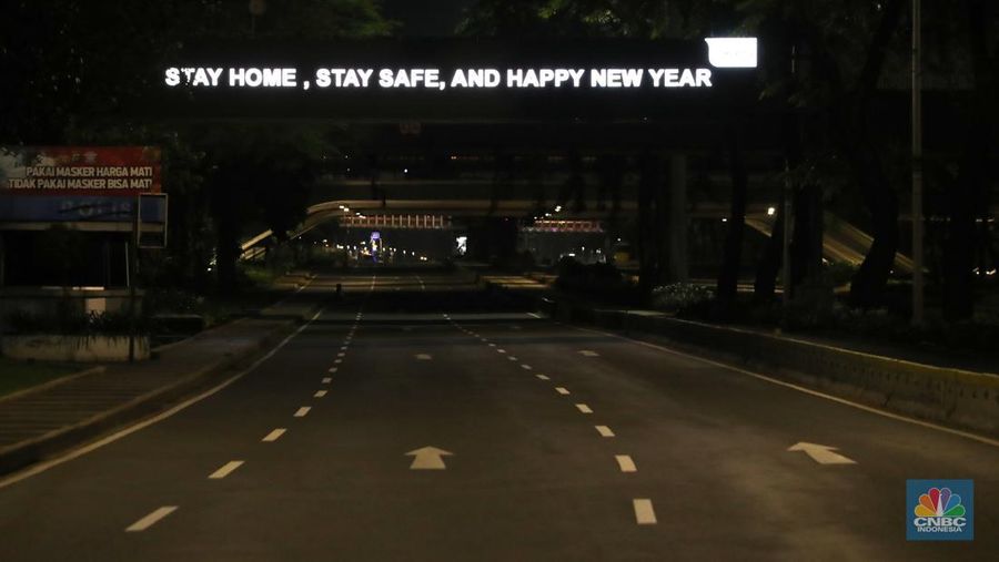 Seorang pedang kopi keliling melewati ruas jalan utama di kawasan jalan Sudirman-Thamrin, Jakarta, Sabtu (1/1/2022). Sejak pukul 22.00 WIB terpantau kendaraan dan warga  sangat lengang. 
Kendaraan operasional polisi tampak menyusuri ruas-ruas jalan yang menjadi titik penutupan jalan.Malam pergantian tahun 2021 menuju 2022 di pusat Kota Jakarta berlangsung sepi. Pemerintah Provinsi DKI Jakarta bersama Polda Metro Jaya menutup 11 ruas jalan sejak pukul 22.00 WIB.
Dari pantauan dilokasi sejumlah ruas jalan di Jakarta terpantau lengang. Tak banyak kendaraan melintas.   
Kendaraan operasional polisi tampak menyusuri ruas-ruas jalan yang menjadi titik penutupan jalan (CNBC Indonesia/ Tri Susilo)