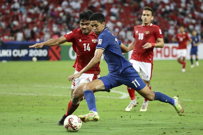 Bordin Phala dari Thailand (kanan) dan Asnawi Mangkualam dari Indonesia bersaing memperebutkan bola pada pertandingan leg kedua final AFF antara Thailand vs Indonesia d National Stadium, Singapura, Sabtu (1/1/2022). (AP Photo/Suhaimi Abdullah)