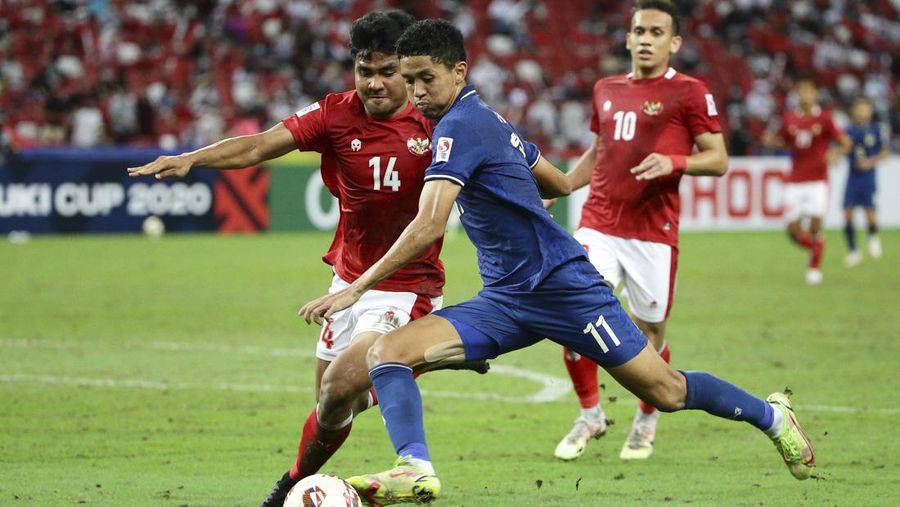Bordin Phala dari Thailand (kanan) dan Asnawi Mangkualam dari Indonesia bersaing memperebutkan bola pada pertandingan leg kedua final AFF antara Thailand vs Indonesia d National Stadium, Singapura, Sabtu (1/1/2022). (AP Photo/Suhaimi Abdullah)