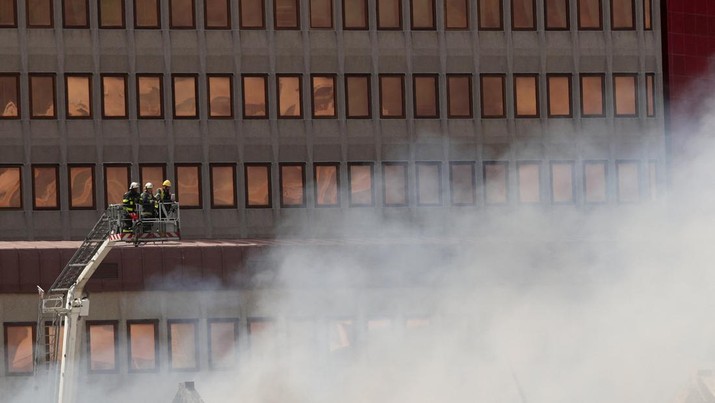 Petugas pemadam memadamkan lokasi kebakaran yang berada di gedung parlemen Cape Town, Afrika Selatan, Minggu (2/1/2022). (REUTERS/Mike Hutchings)