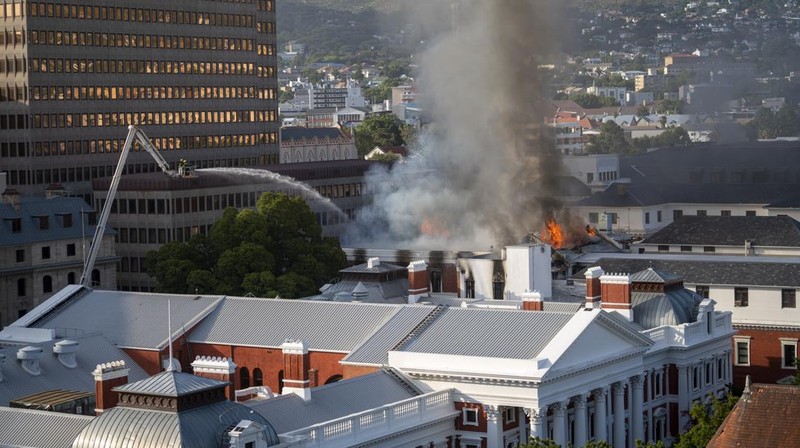 Petugas pemadam memadamkan lokasi kebakaran yang berada di gedung parlemen Cape Town, Afrika Selatan, Minggu (2/1/2022). (REUTERS/Mike Hutchings)