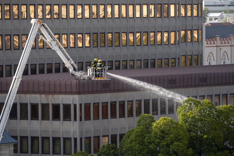 Petugas pemadam memadamkan lokasi kebakaran yang berada di gedung parlemen Cape Town, Afrika Selatan, Minggu (2/1/2022). (REUTERS/Mike Hutchings)