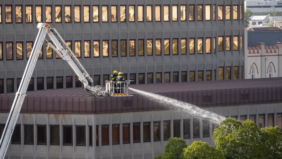 Petugas pemadam memadamkan lokasi kebakaran yang berada di gedung parlemen Cape Town, Afrika Selatan, Minggu (2/1/2022). (REUTERS/Mike Hutchings)