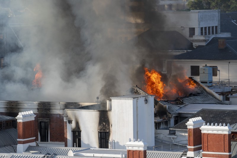 Petugas pemadam memadamkan lokasi kebakaran yang berada di gedung parlemen Cape Town, Afrika Selatan, Minggu (2/1/2022). (REUTERS/Mike Hutchings)
