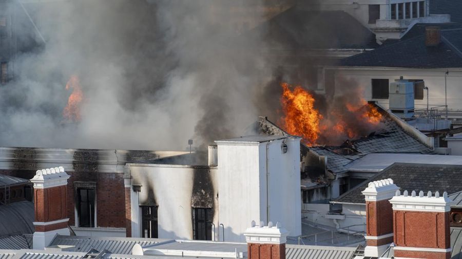 Petugas pemadam memadamkan lokasi kebakaran yang berada di gedung parlemen Cape Town, Afrika Selatan, Minggu (2/1/2022). (REUTERS/Mike Hutchings)