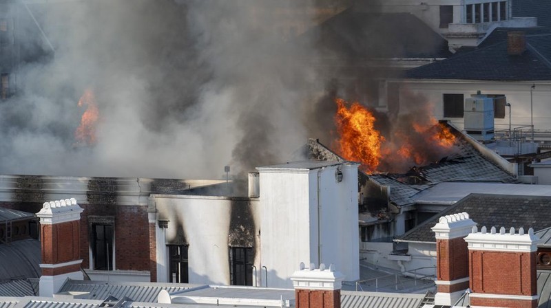 Petugas pemadam memadamkan lokasi kebakaran yang berada di gedung parlemen Cape Town, Afrika Selatan, Minggu (2/1/2022). (REUTERS/Mike Hutchings)