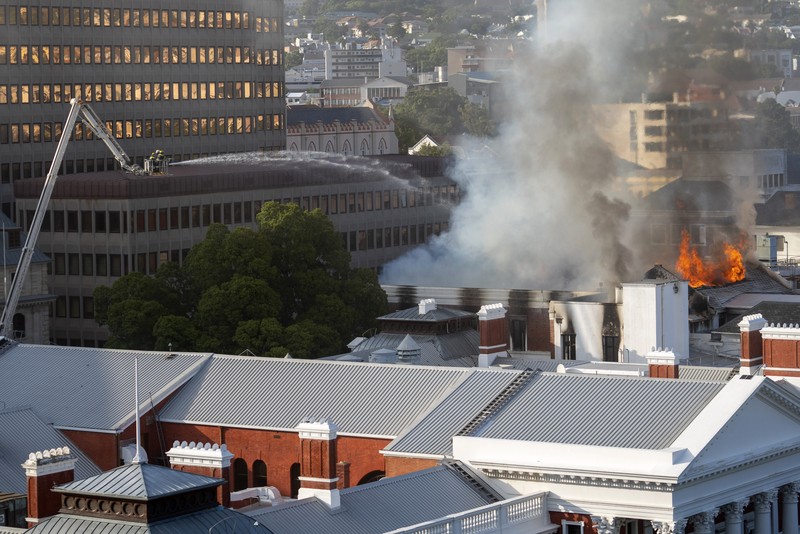 Petugas pemadam memadamkan lokasi kebakaran yang berada di gedung parlemen Cape Town, Afrika Selatan, Minggu (2/1/2022). (REUTERS/Mike Hutchings)