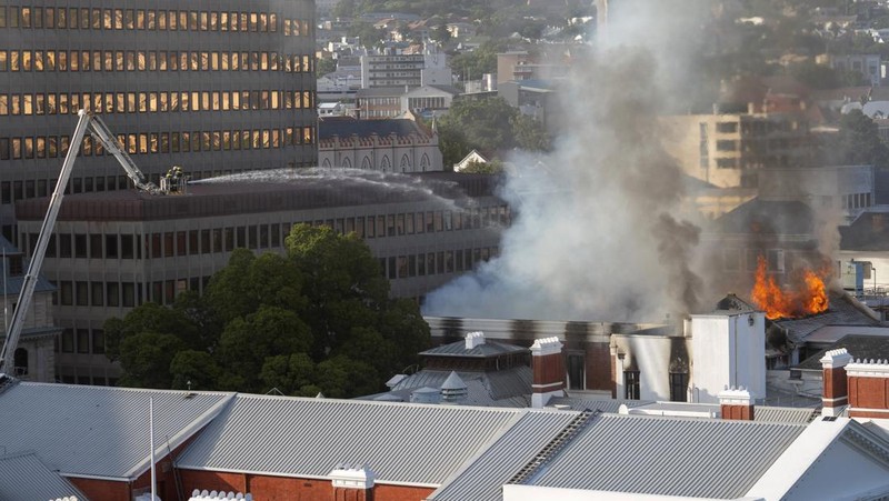 Petugas pemadam memadamkan lokasi kebakaran yang berada di gedung parlemen Cape Town, Afrika Selatan, Minggu (2/1/2022). (REUTERS/Mike Hutchings)