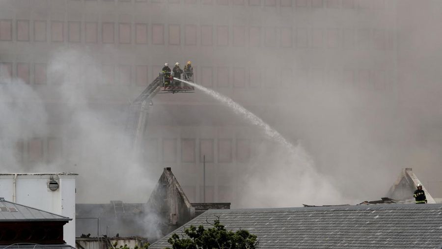 Petugas pemadam memadamkan lokasi kebakaran yang berada di gedung parlemen Cape Town, Afrika Selatan, Minggu (2/1/2022). (REUTERS/Mike Hutchings)