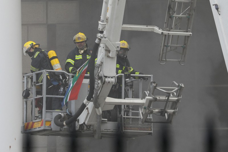 Petugas pemadam memadamkan lokasi kebakaran yang berada di gedung parlemen Cape Town, Afrika Selatan, Minggu (2/1/2022). (REUTERS/Mike Hutchings)