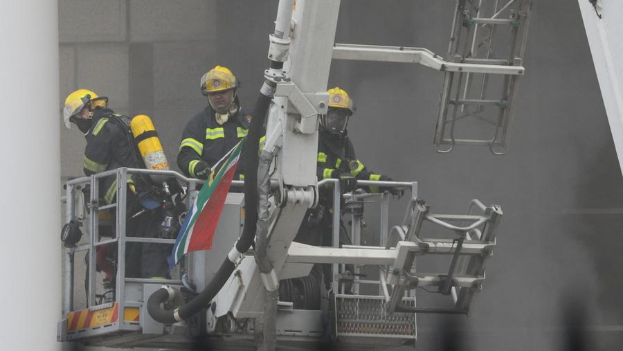 Petugas pemadam kebakaran memadamkan api di lokasi kebakaran yang berada di gedung parlemen di Cape Town, Afrika Selatan, Minggu (2/1/2022). (REUTERS/Sumaya Hisham)