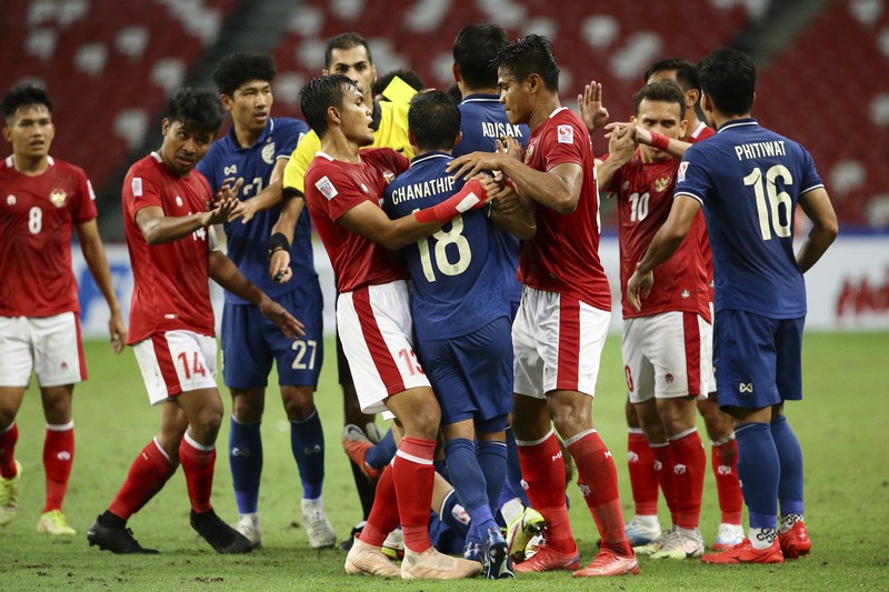Bordin Phala dari Thailand (kanan) dan Asnawi Mangkualam dari Indonesia bersaing memperebutkan bola pada pertandingan leg kedua final AFF antara Thailand vs Indonesia d National Stadium, Singapura, Sabtu (1/1/2022). (AP Photo/Suhaimi Abdullah)