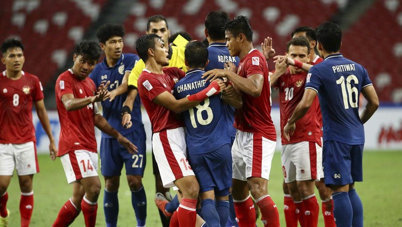 Bordin Phala dari Thailand (kanan) dan Asnawi Mangkualam dari Indonesia bersaing memperebutkan bola pada pertandingan leg kedua final AFF antara Thailand vs Indonesia d National Stadium, Singapura, Sabtu (1/1/2022). (AP Photo/Suhaimi Abdullah)