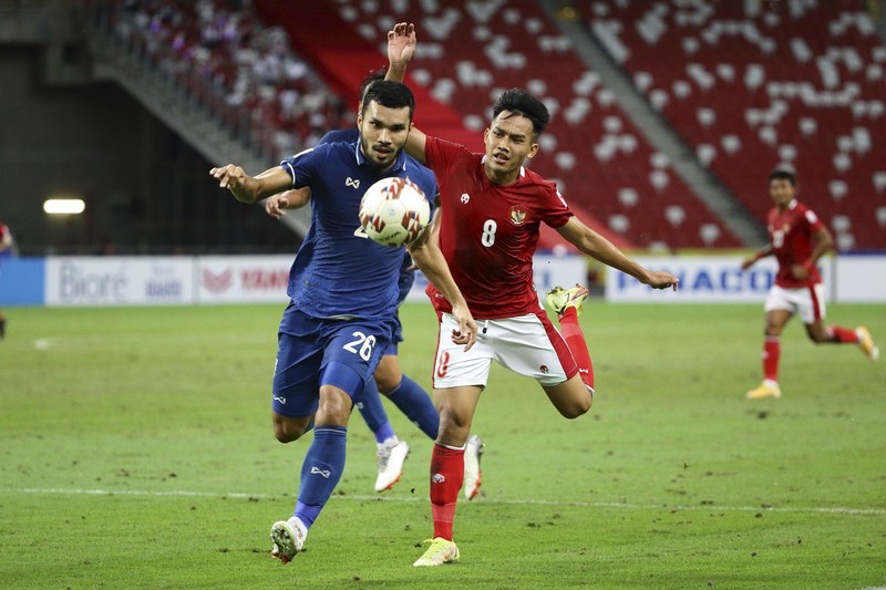 Bordin Phala dari Thailand (kanan) dan Asnawi Mangkualam dari Indonesia bersaing memperebutkan bola pada pertandingan leg kedua final AFF antara Thailand vs Indonesia d National Stadium, Singapura, Sabtu (1/1/2022). (AP Photo/Suhaimi Abdullah)