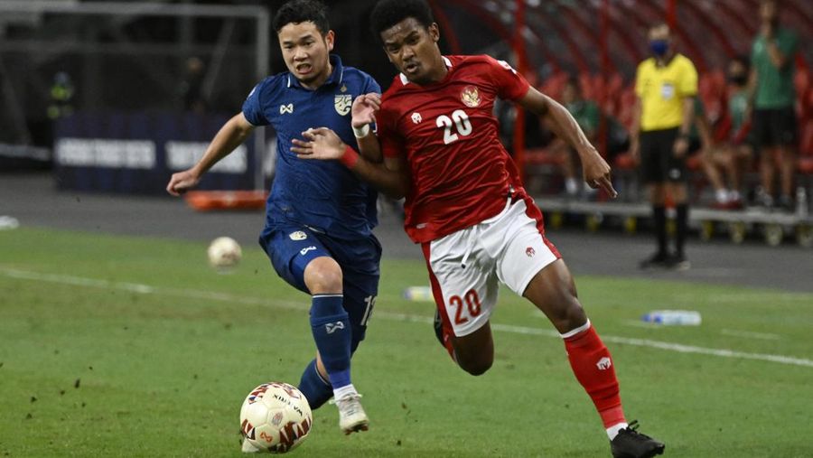 Ramai Rumakiek Indonesia berebut bolda dengan Thanawat Suengchitthawon dari Thailand saat laga leg kedua final AFF antara Thailand vs Indonesia d National Stadium, Singapura, Sabtu (1/1/2022). (REUTERS/Caroline Chia)