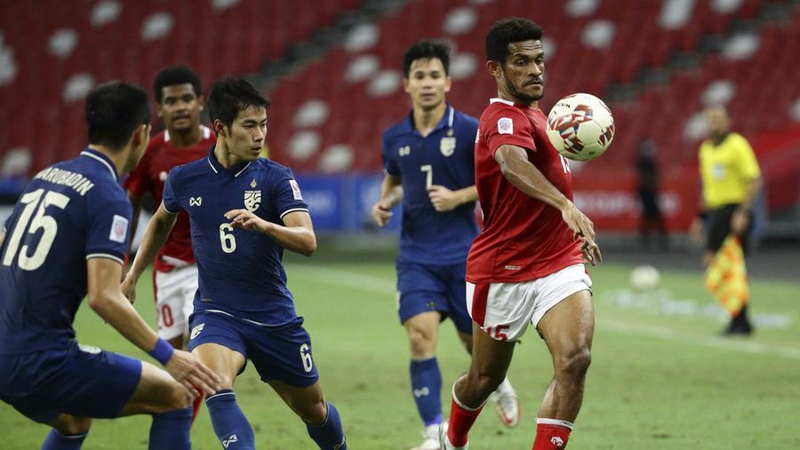 Ricky Richardo Kambuaya dari Indonesia (kanan) membawa bola saat berebut dengan Sarach Yooyen dari Thailand pada pertandingan leg kedua final AFF antara Thailand vs Indonesia d National Stadium, Singapura, Sabtu (1/1/2022). (AP Photo/Suhaimi Abdullah)