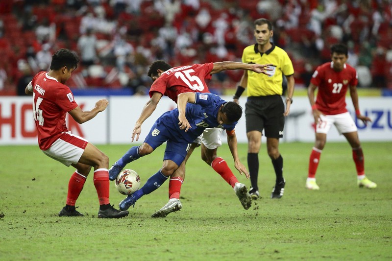 Bordin Phala dari Thailand (kanan) dan Asnawi Mangkualam di Final Leg kedua final AFF antara Thailand vs Indonesia Bordin Phala dari Thailand (kanan) dan Asnawi Mangkualam dari Indonesia bersaing memperebutkan bola pada pertandingan leg kedua final AFF antara Thailand vs Indonesia d National Stadium, Singapura, Sabtu (1/1/2022). (AP Photo/Suhaimi Abdullah)