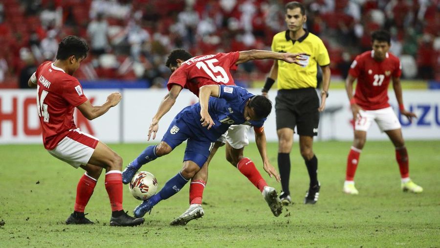 Bordin Phala dari Thailand (kanan) dan Asnawi Mangkualam dari Indonesia bersaing memperebutkan bola pada pertandingan leg kedua final AFF antara Thailand vs Indonesia d National Stadium, Singapura, Sabtu (1/1/2022). (AP Photo/Suhaimi Abdullah)