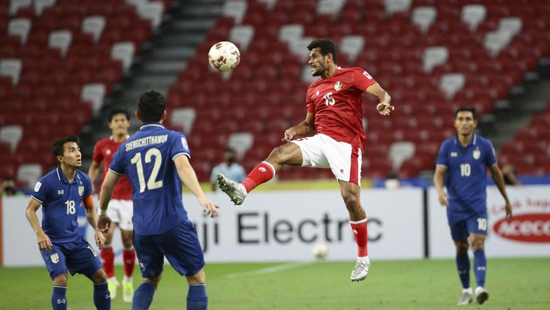 Bordin Phala dari Thailand (kanan) dan Asnawi Mangkualam dari Indonesia bersaing memperebutkan bola pada pertandingan leg kedua final AFF antara Thailand vs Indonesia d National Stadium, Singapura, Sabtu (1/1/2022). (AP Photo/Suhaimi Abdullah)