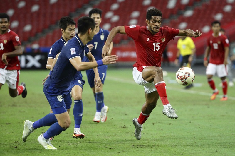 Bordin Phala dari Thailand (kanan) dan Asnawi Mangkualam di Final Leg kedua final AFF antara Thailand vs Indonesia Bordin Phala dari Thailand (kanan) dan Asnawi Mangkualam dari Indonesia bersaing memperebutkan bola pada pertandingan leg kedua final AFF antara Thailand vs Indonesia d National Stadium, Singapura, Sabtu (1/1/2022). (AP Photo/Suhaimi Abdullah)