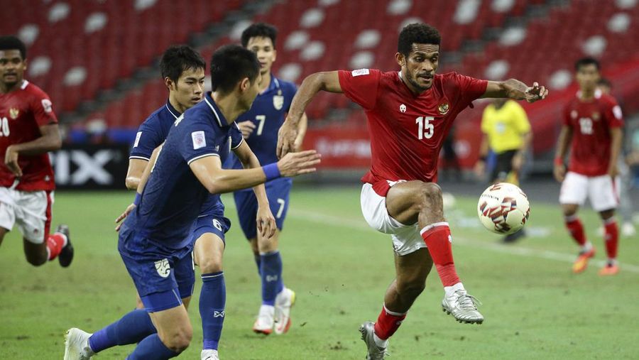 Bordin Phala dari Thailand (kanan) dan Asnawi Mangkualam dari Indonesia bersaing memperebutkan bola pada pertandingan leg kedua final AFF antara Thailand vs Indonesia d National Stadium, Singapura, Sabtu (1/1/2022). (AP Photo/Suhaimi Abdullah)