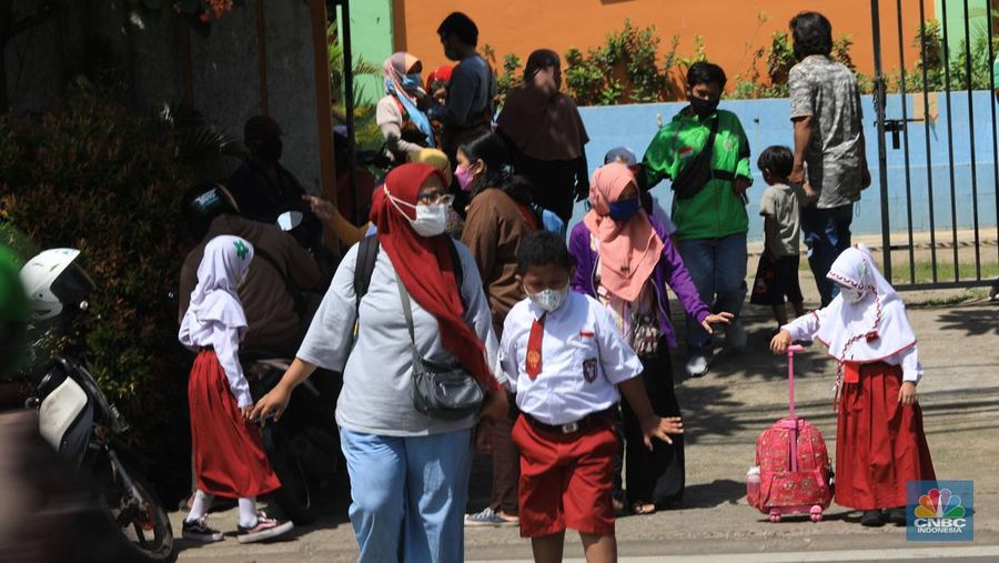 Sejumlah siswa-siswi mengikuti Pembelajaran Tatap Muka (PTM) di Sekolah Dasar Negeri (SDN) 01 Pondok Labu, Jakarta Selatan, Senin (3/1/2022). Pemerintah Provinsi (Pemprov) DKI Jakarta resmi menerapkan Pembelajaran Tatap Muka (PTM) dengan kapasitas 100 persen di seluruh sekolah mulai hari Senin (3/1). Relaksasi kebijakan ini sesuai dengan kondisi PPKM Level 1 yang diterapkan di Jakarta. Kepala bidang kesiswaan SD 01 Muhamad Nasir mengatakan, kebijakan tersebut merefleksikan Surat Keputusan Bersama (SKB) 4 Menteri yang diputuskan pada 21 Desember 2021. SKB dengan Nomor Nomor 05/KB/2021, Nomor 1347 Tahun 2021, Nomor HK.01.08/MENKES/6678/2021, Nomor 443-5847 Tahun 2021 berisi tentang Panduan Penyelenggaraan Pembelajaran di Masa Pandemi Covid-19. Meski dibuka 100 persen, Sekolah mewajibkan semua warga sekolah untuk menerapkan protokol kesehatan secara ketat. Terlebih lagi bagi mereka yang belum divaksinasi. Kebijakan PTM juga disambut baik bagi orang tua murid, Yulia salah satu orang tua murid kelas 2 mengatakan senang setelah dibuat PTM 100%. 