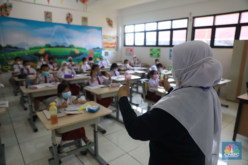 Sejumlah siswa-siswi mengikuti Pembelajaran Tatap Muka (PTM) di Sekolah Dasar Negeri (SDN) 01 Pondok Labu Sejumlah siswa-siswi mengikuti Pembelajaran Tatap Muka (PTM) di Sekolah Dasar Negeri (SDN) 01 Pondok Labu, Jakarta Selatan, Senin (3/1/2022). Pemerintah Provinsi (Pemprov) DKI Jakarta resmi menerapkan Pembelajaran Tatap Muka (PTM) dengan kapasitas 100 persen di seluruh sekolah mulai hari Senin (3/1). Relaksasi kebijakan ini sesuai dengan kondisi PPKM Level 1 yang diterapkan di Jakarta. Kepala bidang kesiswaan SD 01 Muhamad Nasir mengatakan, kebijakan tersebut merefleksikan Surat Keputusan Bersama (SKB) 4 Menteri yang diputuskan pada 21 Desember 2021. SKB dengan Nomor Nomor 05/KB/2021, Nomor 1347 Tahun 2021, Nomor HK.01.08/MENKES/6678/2021, Nomor 443-5847 Tahun 2021 berisi tentang Panduan Penyelenggaraan Pembelajaran di Masa Pandemi Covid-19. Meski dibuka 100 persen, Sekolah mewajibkan semua warga sekolah untuk menerapkan protokol kesehatan secara ketat. Terlebih lagi bagi mereka yang belum divaksinasi. Kebijakan PTM juga disambut baik bagi orang tua murid, Yulia salah satu orang tua murid kelas 2 mengatakan senang setelah dibuat PTM 100%.