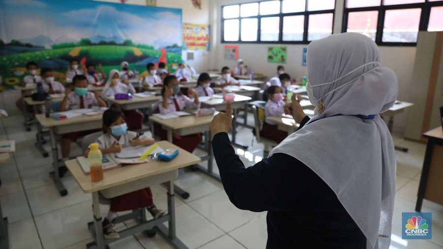 Sejumlah siswa-siswi mengikuti Pembelajaran Tatap Muka (PTM) di Sekolah Dasar Negeri (SDN) 01 Pondok Labu, Jakarta Selatan, Senin (3/1/2022). Pemerintah Provinsi (Pemprov) DKI Jakarta resmi menerapkan Pembelajaran Tatap Muka (PTM) dengan kapasitas 100 persen di seluruh sekolah mulai hari Senin (3/1). Relaksasi kebijakan ini sesuai dengan kondisi PPKM Level 1 yang diterapkan di Jakarta. Kepala bidang kesiswaan SD 01 Muhamad Nasir mengatakan, kebijakan tersebut merefleksikan Surat Keputusan Bersama (SKB) 4 Menteri yang diputuskan pada 21 Desember 2021. SKB dengan Nomor Nomor 05/KB/2021, Nomor 1347 Tahun 2021, Nomor HK.01.08/MENKES/6678/2021, Nomor 443-5847 Tahun 2021 berisi tentang Panduan Penyelenggaraan Pembelajaran di Masa Pandemi Covid-19. Meski dibuka 100 persen, Sekolah mewajibkan semua warga sekolah untuk menerapkan protokol kesehatan secara ketat. Terlebih lagi bagi mereka yang belum divaksinasi. Kebijakan PTM juga disambut baik bagi orang tua murid, Yulia salah satu orang tua murid kelas 2 mengatakan senang setelah dibuat PTM 100%. 