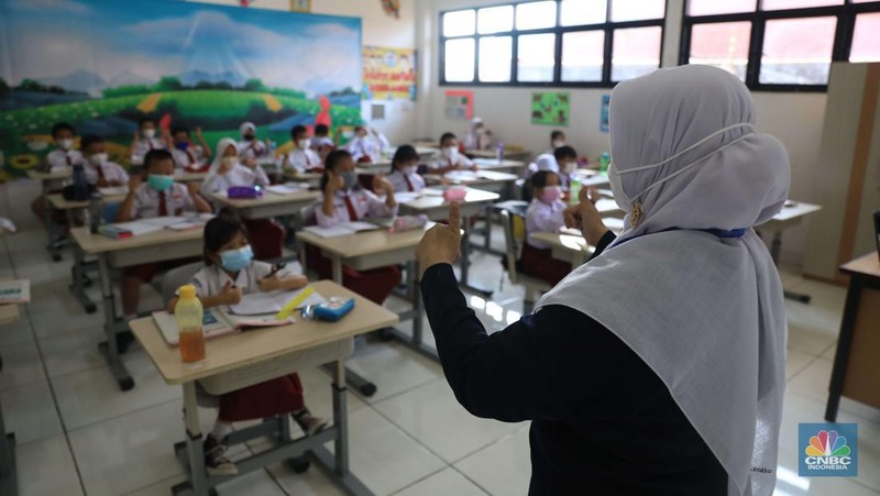 Sejumlah siswa-siswi mengikuti Pembelajaran Tatap Muka (PTM) di Sekolah Dasar Negeri (SDN) 01 Pondok Labu, Jakarta Selatan, Senin (3/1/2022). Pemerintah Provinsi (Pemprov) DKI Jakarta resmi menerapkan Pembelajaran Tatap Muka (PTM) dengan kapasitas 100 persen di seluruh sekolah mulai hari Senin (3/1). Relaksasi kebijakan ini sesuai dengan kondisi PPKM Level 1 yang diterapkan di Jakarta. Kepala bidang kesiswaan SD 01 Muhamad Nasir mengatakan, kebijakan tersebut merefleksikan Surat Keputusan Bersama (SKB) 4 Menteri yang diputuskan pada 21 Desember 2021. SKB dengan Nomor Nomor 05/KB/2021, Nomor 1347 Tahun 2021, Nomor HK.01.08/MENKES/6678/2021, Nomor 443-5847 Tahun 2021 berisi tentang Panduan Penyelenggaraan Pembelajaran di Masa Pandemi Covid-19. Meski dibuka 100 persen, Sekolah mewajibkan semua warga sekolah untuk menerapkan protokol kesehatan secara ketat. Terlebih lagi bagi mereka yang belum divaksinasi. Kebijakan PTM juga disambut baik bagi orang tua murid, Yulia salah satu orang tua murid kelas 2 mengatakan senang setelah dibuat PTM 100%. 