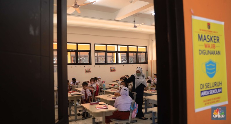 Sejumlah siswa-siswi mengikuti Pembelajaran Tatap Muka (PTM) di Sekolah Dasar Negeri (SDN) 01 Pondok Labu Sejumlah siswa-siswi mengikuti Pembelajaran Tatap Muka (PTM) di Sekolah Dasar Negeri (SDN) 01 Pondok Labu, Jakarta Selatan, Senin (3/1/2022). Pemerintah Provinsi (Pemprov) DKI Jakarta resmi menerapkan Pembelajaran Tatap Muka (PTM) dengan kapasitas 100 persen di seluruh sekolah mulai hari Senin (3/1). Relaksasi kebijakan ini sesuai dengan kondisi PPKM Level 1 yang diterapkan di Jakarta. Kepala bidang kesiswaan SD 01 Muhamad Nasir mengatakan, kebijakan tersebut merefleksikan Surat Keputusan Bersama (SKB) 4 Menteri yang diputuskan pada 21 Desember 2021. SKB dengan Nomor Nomor 05/KB/2021, Nomor 1347 Tahun 2021, Nomor HK.01.08/MENKES/6678/2021, Nomor 443-5847 Tahun 2021 berisi tentang Panduan Penyelenggaraan Pembelajaran di Masa Pandemi Covid-19. Meski dibuka 100 persen, Sekolah mewajibkan semua warga sekolah untuk menerapkan protokol kesehatan secara ketat. Terlebih lagi bagi mereka yang belum divaksinasi. Kebijakan PTM juga disambut baik bagi orang tua murid, Yulia salah satu orang tua murid kelas 2 mengatakan senang setelah dibuat PTM 100%.
