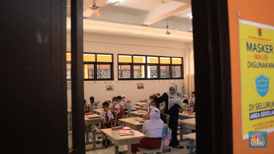 Sejumlah siswa-siswi mengikuti Pembelajaran Tatap Muka (PTM) di Sekolah Dasar Negeri (SDN) 01 Pondok Labu, Jakarta Selatan, Senin (3/1/2022). Pemerintah Provinsi (Pemprov) DKI Jakarta resmi menerapkan Pembelajaran Tatap Muka (PTM) dengan kapasitas 100 persen di seluruh sekolah mulai hari Senin (3/1). Relaksasi kebijakan ini sesuai dengan kondisi PPKM Level 1 yang diterapkan di Jakarta. Kepala bidang kesiswaan SD 01 Muhamad Nasir mengatakan, kebijakan tersebut merefleksikan Surat Keputusan Bersama (SKB) 4 Menteri yang diputuskan pada 21 Desember 2021. SKB dengan Nomor Nomor 05/KB/2021, Nomor 1347 Tahun 2021, Nomor HK.01.08/MENKES/6678/2021, Nomor 443-5847 Tahun 2021 berisi tentang Panduan Penyelenggaraan Pembelajaran di Masa Pandemi Covid-19. Meski dibuka 100 persen, Sekolah mewajibkan semua warga sekolah untuk menerapkan protokol kesehatan secara ketat. Terlebih lagi bagi mereka yang belum divaksinasi. Kebijakan PTM juga disambut baik bagi orang tua murid, Yulia salah satu orang tua murid kelas 2 mengatakan senang setelah dibuat PTM 100%.
