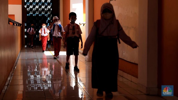 Sejumlah siswa-siswi mengikuti Pembelajaran Tatap Muka (PTM) di Sekolah Dasar Negeri (SDN) 01 Pondok Labu, Jakarta Selatan, Senin (3/1/2022). Pemerintah Provinsi (Pemprov) DKI Jakarta resmi menerapkan Pembelajaran Tatap Muka (PTM) dengan kapasitas 100 persen di seluruh sekolah mulai hari Senin (3/1). Relaksasi kebijakan ini sesuai dengan kondisi PPKM Level 1 yang diterapkan di Jakarta. Kepala bidang kesiswaan SD 01 Muhamad Nasir mengatakan, kebijakan tersebut merefleksikan Surat Keputusan Bersama (SKB) 4 Menteri yang diputuskan pada 21 Desember 2021. SKB dengan Nomor Nomor 05/KB/2021, Nomor 1347 Tahun 2021, Nomor HK.01.08/MENKES/6678/2021, Nomor 443-5847 Tahun 2021 berisi tentang Panduan Penyelenggaraan Pembelajaran di Masa Pandemi Covid-19. Meski dibuka 100 persen, Sekolah mewajibkan semua warga sekolah untuk menerapkan protokol kesehatan secara ketat. Terlebih lagi bagi mereka yang belum divaksinasi. Kebijakan PTM juga disambut baik bagi orang tua murid, Yulia salah satu orang tua murid kelas 2 mengatakan senang setelah dibuat PTM 100%.
