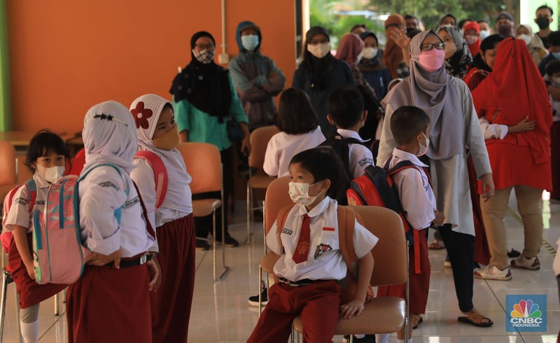 Sejumlah siswa-siswi mengikuti Pembelajaran Tatap Muka (PTM) di Sekolah Dasar Negeri (SDN) 01 Pondok Labu Sejumlah siswa-siswi mengikuti Pembelajaran Tatap Muka (PTM) di Sekolah Dasar Negeri (SDN) 01 Pondok Labu, Jakarta Selatan, Senin (3/1/2022). Pemerintah Provinsi (Pemprov) DKI Jakarta resmi menerapkan Pembelajaran Tatap Muka (PTM) dengan kapasitas 100 persen di seluruh sekolah mulai hari Senin (3/1). Relaksasi kebijakan ini sesuai dengan kondisi PPKM Level 1 yang diterapkan di Jakarta. Kepala bidang kesiswaan SD 01 Muhamad Nasir mengatakan, kebijakan tersebut merefleksikan Surat Keputusan Bersama (SKB) 4 Menteri yang diputuskan pada 21 Desember 2021. SKB dengan Nomor Nomor 05/KB/2021, Nomor 1347 Tahun 2021, Nomor HK.01.08/MENKES/6678/2021, Nomor 443-5847 Tahun 2021 berisi tentang Panduan Penyelenggaraan Pembelajaran di Masa Pandemi Covid-19. Meski dibuka 100 persen, Sekolah mewajibkan semua warga sekolah untuk menerapkan protokol kesehatan secara ketat. Terlebih lagi bagi mereka yang belum divaksinasi. Kebijakan PTM juga disambut baik bagi orang tua murid, Yulia salah satu orang tua murid kelas 2 mengatakan senang setelah dibuat PTM 100%.