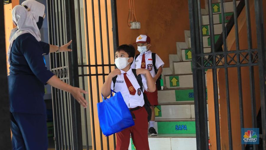 Sejumlah siswa-siswi mengikuti Pembelajaran Tatap Muka (PTM) di Sekolah Dasar Negeri (SDN) 01 Pondok Labu, Jakarta Selatan, Senin (3/1/2022). Pemerintah Provinsi (Pemprov) DKI Jakarta resmi menerapkan Pembelajaran Tatap Muka (PTM) dengan kapasitas 100 persen di seluruh sekolah mulai hari Senin (3/1). Relaksasi kebijakan ini sesuai dengan kondisi PPKM Level 1 yang diterapkan di Jakarta. Kepala bidang kesiswaan SD 01 Muhamad Nasir mengatakan, kebijakan tersebut merefleksikan Surat Keputusan Bersama (SKB) 4 Menteri yang diputuskan pada 21 Desember 2021. SKB dengan Nomor Nomor 05/KB/2021, Nomor 1347 Tahun 2021, Nomor HK.01.08/MENKES/6678/2021, Nomor 443-5847 Tahun 2021 berisi tentang Panduan Penyelenggaraan Pembelajaran di Masa Pandemi Covid-19. Meski dibuka 100 persen, Sekolah mewajibkan semua warga sekolah untuk menerapkan protokol kesehatan secara ketat. Terlebih lagi bagi mereka yang belum divaksinasi. Kebijakan PTM juga disambut baik bagi orang tua murid, Yulia salah satu orang tua murid kelas 2 mengatakan senang setelah dibuat PTM 100%.