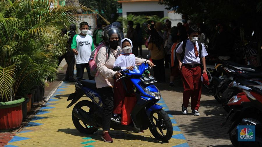 Sejumlah siswa-siswi mengikuti Pembelajaran Tatap Muka (PTM) di Sekolah Dasar Negeri (SDN) 01 Pondok Labu, Jakarta Selatan, Senin (3/1/2022). Pemerintah Provinsi (Pemprov) DKI Jakarta resmi menerapkan Pembelajaran Tatap Muka (PTM) dengan kapasitas 100 persen di seluruh sekolah mulai hari Senin (3/1). Relaksasi kebijakan ini sesuai dengan kondisi PPKM Level 1 yang diterapkan di Jakarta. Kepala bidang kesiswaan SD 01 Muhamad Nasir mengatakan, kebijakan tersebut merefleksikan Surat Keputusan Bersama (SKB) 4 Menteri yang diputuskan pada 21 Desember 2021. SKB dengan Nomor Nomor 05/KB/2021, Nomor 1347 Tahun 2021, Nomor HK.01.08/MENKES/6678/2021, Nomor 443-5847 Tahun 2021 berisi tentang Panduan Penyelenggaraan Pembelajaran di Masa Pandemi Covid-19. Meski dibuka 100 persen, Sekolah mewajibkan semua warga sekolah untuk menerapkan protokol kesehatan secara ketat. Terlebih lagi bagi mereka yang belum divaksinasi. Kebijakan PTM juga disambut baik bagi orang tua murid, Yulia salah satu orang tua murid kelas 2 mengatakan senang setelah dibuat PTM 100%.