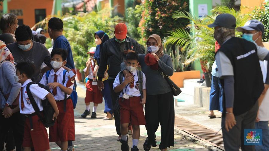 Sejumlah siswa-siswi mengikuti Pembelajaran Tatap Muka (PTM) di Sekolah Dasar Negeri (SDN) 01 Pondok Labu, Jakarta Selatan, Senin (3/1/2022). Pemerintah Provinsi (Pemprov) DKI Jakarta resmi menerapkan Pembelajaran Tatap Muka (PTM) dengan kapasitas 100 persen di seluruh sekolah mulai hari Senin (3/1). Relaksasi kebijakan ini sesuai dengan kondisi PPKM Level 1 yang diterapkan di Jakarta. Kepala bidang kesiswaan SD 01 Muhamad Nasir mengatakan, kebijakan tersebut merefleksikan Surat Keputusan Bersama (SKB) 4 Menteri yang diputuskan pada 21 Desember 2021. SKB dengan Nomor Nomor 05/KB/2021, Nomor 1347 Tahun 2021, Nomor HK.01.08/MENKES/6678/2021, Nomor 443-5847 Tahun 2021 berisi tentang Panduan Penyelenggaraan Pembelajaran di Masa Pandemi Covid-19. Meski dibuka 100 persen, Sekolah mewajibkan semua warga sekolah untuk menerapkan protokol kesehatan secara ketat. Terlebih lagi bagi mereka yang belum divaksinasi. Kebijakan PTM juga disambut baik bagi orang tua murid, Yulia salah satu orang tua murid kelas 2 mengatakan senang setelah dibuat PTM 100%. 