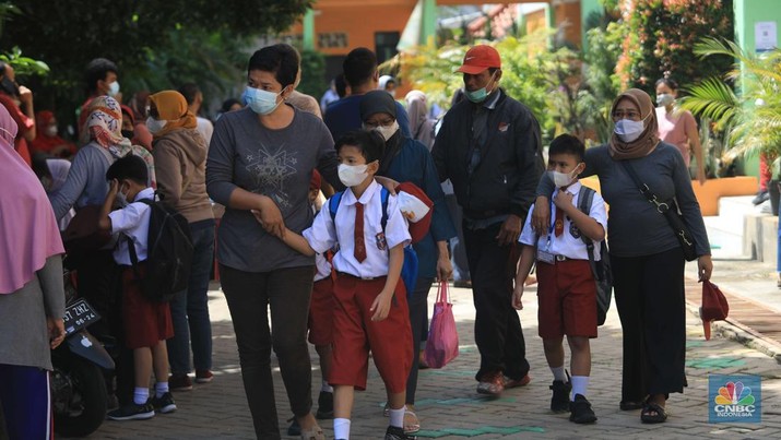 Sejumlah siswa-siswi mengikuti Pembelajaran Tatap Muka (PTM) di Sekolah Dasar Negeri (SDN) 01 Pondok Labu Sejumlah siswa-siswi mengikuti Pembelajaran Tatap Muka (PTM) di Sekolah Dasar Negeri (SDN) 01 Pondok Labu, Jakarta Selatan, Senin (3/1/2022). Pemerintah Provinsi (Pemprov) DKI Jakarta resmi menerapkan Pembelajaran Tatap Muka (PTM) dengan kapasitas 100 persen di seluruh sekolah mulai hari Senin (3/1). Relaksasi kebijakan ini sesuai dengan kondisi PPKM Level 1 yang diterapkan di Jakarta. Kepala bidang kesiswaan SD 01 Muhamad Nasir mengatakan, kebijakan tersebut merefleksikan Surat Keputusan Bersama (SKB) 4 Menteri yang diputuskan pada 21 Desember 2021. SKB dengan Nomor Nomor 05/KB/2021, Nomor 1347 Tahun 2021, Nomor HK.01.08/MENKES/6678/2021, Nomor 443-5847 Tahun 2021 berisi tentang Panduan Penyelenggaraan Pembelajaran di Masa Pandemi Covid-19. Meski dibuka 100 persen, Sekolah mewajibkan semua warga sekolah untuk menerapkan protokol kesehatan secara ketat. Terlebih lagi bagi mereka yang belum divaksinasi. Kebijakan PTM juga disambut baik bagi orang tua murid, Yulia salah satu orang tua murid kelas 2 mengatakan senang setelah dibuat PTM 100%.