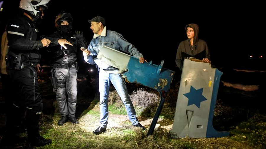 Petugas memegang bagian dari helikopter militer Israel yang jatuh di lepas pantai Mediterania dekat Haifa,  Israel (3/1/2022). (REUTERS/ Rami Shlush)