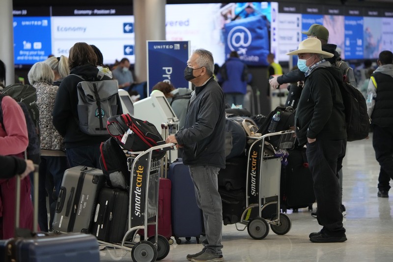 Pembatalan Penerbangan Pesawat di Bandara Internasional Denver, AS, Amerika Serikat Penumpang mengantre di pos pemeriksaan keamanan di terminal utama Bandara Internasional Denver di Denver, Senin (3/1/2022). (AP/David Zalubowski)