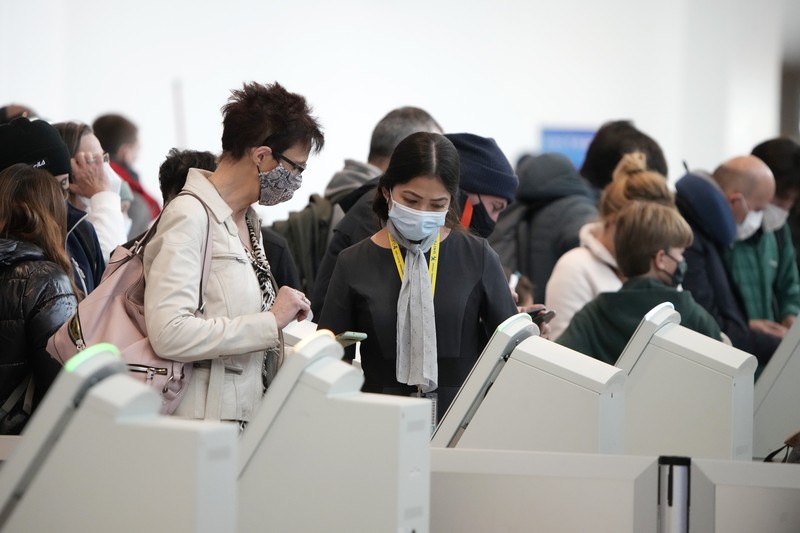 Penumpang mengantre di pos pemeriksaan keamanan di terminal utama Bandara Internasional Denver di Denver, Senin (3/1/2022).  (AP/David Zalubowski)