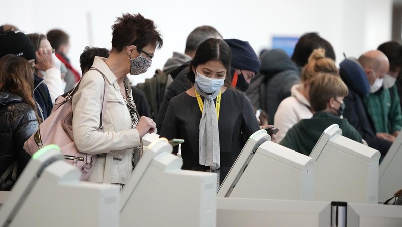 Penumpang mengantre di pos pemeriksaan keamanan di terminal utama Bandara Internasional Denver di Denver, Senin (3/1/2022).  (AP/David Zalubowski)