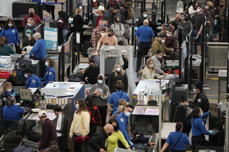 Penumpang mengantre di pos pemeriksaan keamanan di terminal utama Bandara Internasional Denver di Denver, Senin (3/1/2022).  (AP/David Zalubowski)