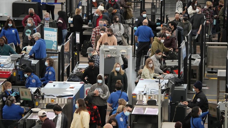 Penumpang mengantre di pos pemeriksaan keamanan di terminal utama Bandara Internasional Denver di Denver, Senin (3/1/2022).  (AP/David Zalubowski)