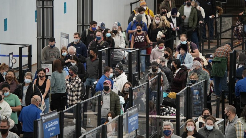 Penumpang mengantre di pos pemeriksaan keamanan di terminal utama Bandara Internasional Denver di Denver, Senin (3/1/2022).  (AP/David Zalubowski)