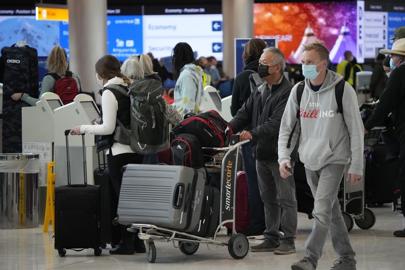 Pembatalan Penerbangan Pesawat di Bandara Internasional Denver, AS, Amerika Serikat Penumpang mengantre di pos pemeriksaan keamanan di terminal utama Bandara Internasional Denver di Denver, Senin (3/1/2022). (AP/David Zalubowski)
