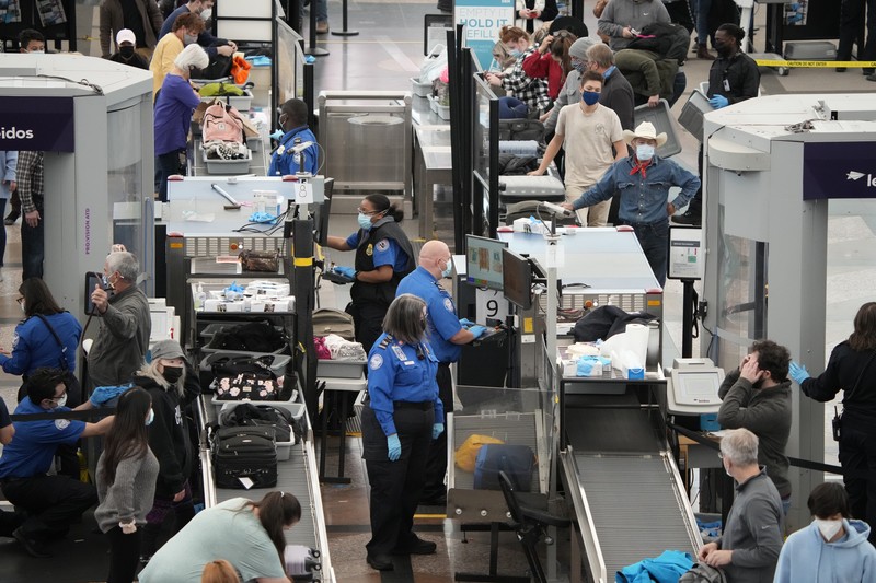 Pembatalan Penerbangan Pesawat di Bandara Internasional Denver, AS, Amerika Serikat Penumpang mengantre di pos pemeriksaan keamanan di terminal utama Bandara Internasional Denver di Denver, Senin (3/1/2022). (AP/David Zalubowski)