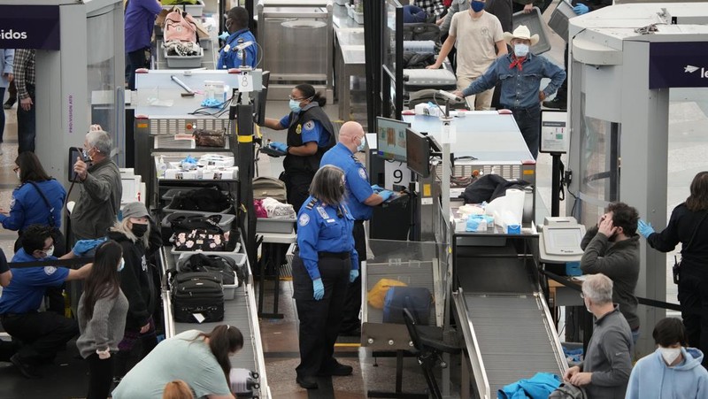 Penumpang mengantre di pos pemeriksaan keamanan di terminal utama Bandara Internasional Denver di Denver, Senin (3/1/2022).  (AP/David Zalubowski)