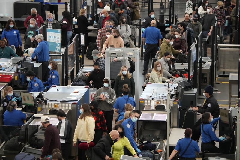 Pembatalan Penerbangan Pesawat di Bandara Internasional Denver, AS, Amerika Serikat Penumpang mengantre di pos pemeriksaan keamanan di terminal utama Bandara Internasional Denver di Denver, Senin (3/1/2022). (AP/David Zalubowski)