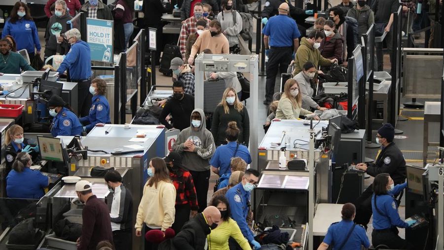 Penumpang mengantre untuk melewati pos pemeriksaan keamanan sdi terminal utama Bandara Internasional Denver di Denver, Senin (3/1/2022). (AP/David Zalubowski)