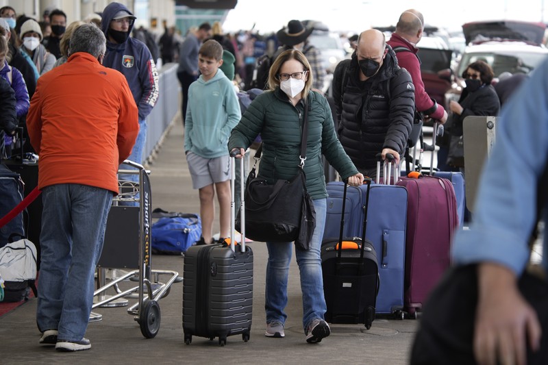 Pembatalan Penerbangan Pesawat di Bandara Internasional Denver, AS, Amerika Serikat Penumpang mengantre di pos pemeriksaan keamanan di terminal utama Bandara Internasional Denver di Denver, Senin (3/1/2022). (AP/David Zalubowski)